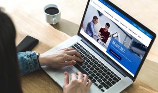 A woman views the Widener homepage on a laptop screen