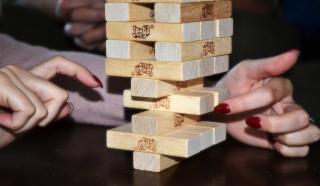 Hands moving a Jenga piece