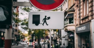 A sign depicting a delivery person holding a package