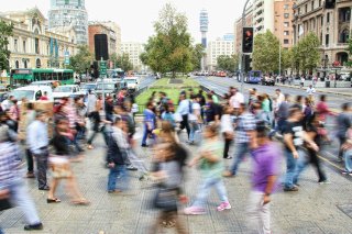 Blurred people walking across a crosswalk